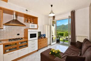 a living room with a couch and a kitchen at Calla in Colico