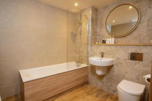 a bathroom with a sink toilet and a mirror at Budock Vean Hotel and Spa in Falmouth