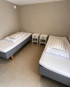 two beds in a room with two tables at Olavsberget camping in Porsgrunn