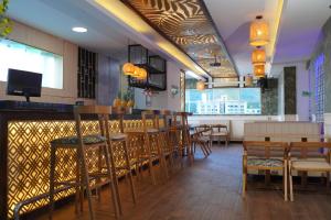 a restaurant with tables and chairs and a bar at Hotel Medellín Rodadero in Santa Marta
