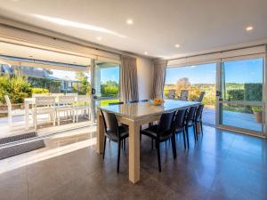 a dining room with a wooden table and chairs at Bella Seven- Stay Waiheke in Oneroa