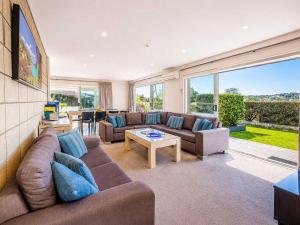 a living room with a couch and a table at Bella Seven- Stay Waiheke in Oneroa