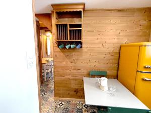 a kitchen with a white table and a yellow refrigerator at Apparts'Hôtel Aspe in Bedous +13 photos