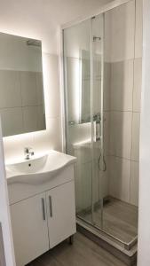 a white bathroom with a sink and a shower at Villa Loukia in Corfu +53 photos