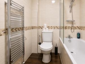 a bathroom with a toilet and a bath tub at Spacious flat in Streatham in London