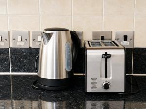 a coffee maker and a toaster on a counter at Spacious flat in Streatham in London