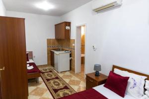 a small room with two beds and a kitchen at Kasneci Apartments in Ulcinj