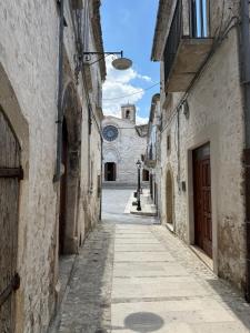 an alley in an old building with a clock tower at Ad un Passo dal Duomo in Bovino
