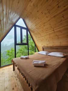 a large bed in a room with a large window at Machaxela Skyline in Tsʼkhemlisi