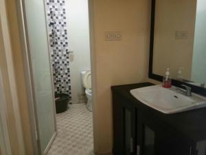 a bathroom with a sink and a toilet and a mirror at Villa Batu Iggy in Batu