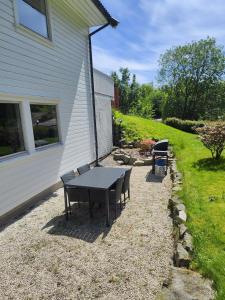 a picnic table and benches next to a house at Cozy pet-friendly apartment with parking in Flekkefjord