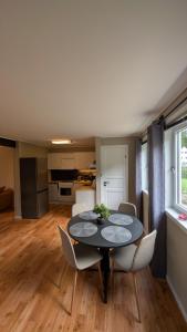 a dining room with a table and chairs and a kitchen at Cozy pet-friendly apartment with parking in Flekkefjord