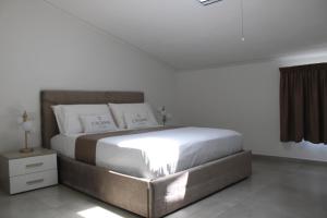 a bed in a white room with a bedskirtspectspectspectspects at Cridima Luxury - Villa Hera in Santa Maria La Carità +12 photos