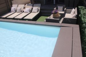 a swimming pool with a couch next to a swimming pool at Cridima Luxury - Villa Hera in Santa Maria La Carità