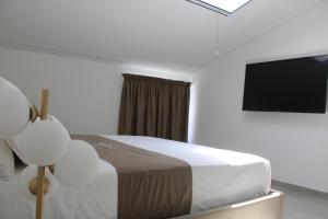 a bedroom with a bed and a flat screen tv at Cridima Luxury - Villa Hera in Santa Maria La Carità
