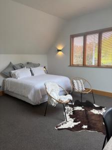 a bedroom with a large bed and two chairs at Spacious 1 Bed apartment City centre in Palmerston North