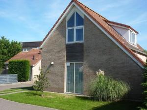 a brick house with a large window at Bungalow in Breskens near Beach & Lighthouse in Breskens
