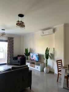 a living room with a couch and a tv at GAIA Penthouse in El Dab‘a