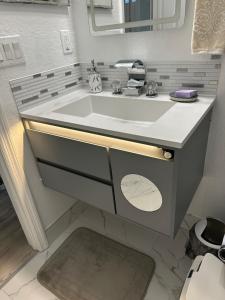 a bathroom with a white sink and a mirror at Quiet room in a family home in Lehigh Acres +30 photos