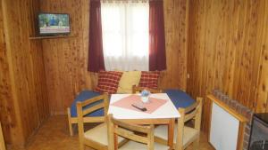 a room with a table and chairs and a window at Complejo Villa Azul in Esquel