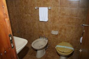 a small bathroom with a toilet and a sink at Complejo Villa Azul in Esquel +14 photos