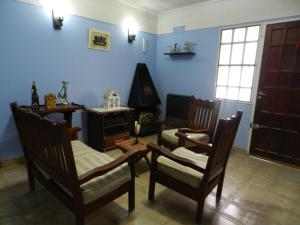 a living room with chairs and a table and a stove at Lo de Lili in Puerto Madryn
