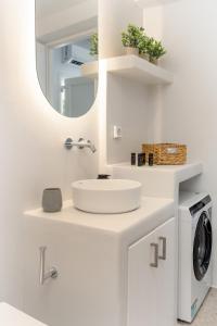 a bathroom with a sink and a washing machine at Pyrgaki Hideout Beachfront Apartment in Agiassos +32 photos