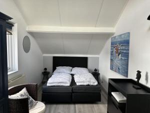 a bedroom with a bed and a desk in it at Bungalow in Breskens near Beach & Lighthouse in Breskens +15 photos
