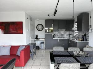 a living room with a red couch and a kitchen at Bungalow in Breskens near Beach & Lighthouse in Breskens