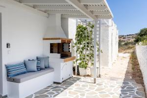 a patio with a bench on the side of a building at Pyrgaki Hideout Beachfront Apartment in Agiassos