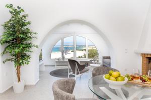 a living room with a table and chairs and the ocean at Pyrgaki Hideout Beachfront Apartment in Agiassos