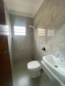 a bathroom with a toilet and a sink at Harmony House Hospedagem in Votuporanga