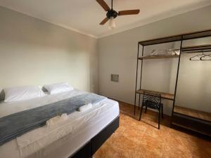 a bedroom with a bed with a ceiling fan at Harmony House Hospedagem in Votuporanga