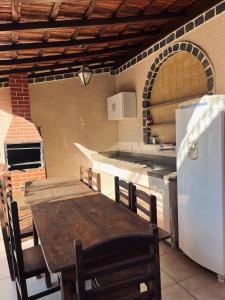 a kitchen with a wooden table and a refrigerator at Encanto da Serra casa 1 in Miguel Pereira