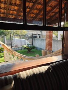 a view from a window of a hammock in a yard at Encanto da Serra casa 1 in Miguel Pereira