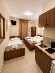 a hotel room with two beds and a kitchen at JONNY'S Rooms in Paralia Katerinis