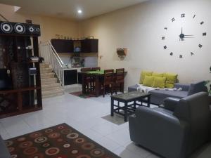 a living room with a couch and a clock on the wall at Villa Batu Iggy in Batu