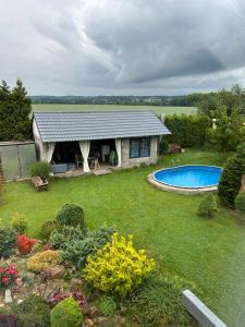 a garden with a house and a swimming pool at U zlatého křížku in Loukov