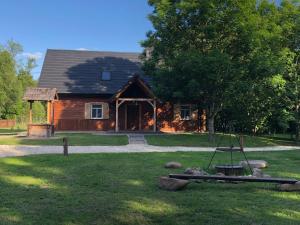 a log cabin with a tree and a swing at ALVORADA Mościce Dolne nad Bugiem in Nowosiółki