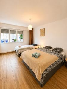 a bedroom with two beds and a couch at 5 lits, 3Ch, 100m2, Free Parking, Spacieux in Pau +7 photos
