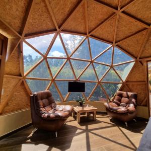 two chairs in a room with a large window at Glamping Green Garden Suite in Villa de Leyva +10 photos