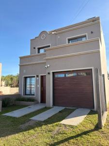 a house with a garage door in front of it at Los Aromos Sinsacate in Sinsacate
