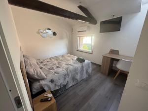 a bedroom with a bed and a desk and a window at La maison Sophel in Pieris +7 photos