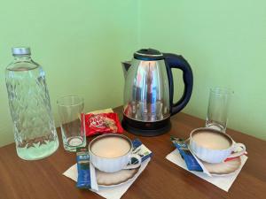 a table with two cups of coffee and a tea pot at Gezim guest house in Shirokë