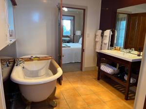 a bathroom with a large tub and a sink at Waipoua Lodge in Aranga +17 photos
