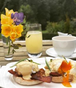 a table with two plates of food and a glass of milk at Waipoua Lodge in Aranga