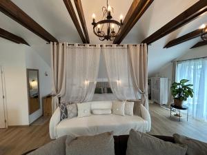 a living room with a white couch and a chandelier at U zlatého křížku in Loukov +100 photos