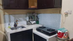 a small kitchen with a sink and a stove at Villa Batu Iggy in Batu +6 photos