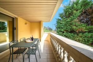 a table and chairs on the balcony of a house at LE MARNI appartement central avec terrasse parking privé in Menton