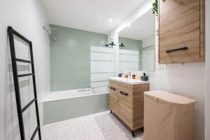a bathroom with a sink and a bath tub at LE MARNI appartement central avec terrasse parking privé in Menton